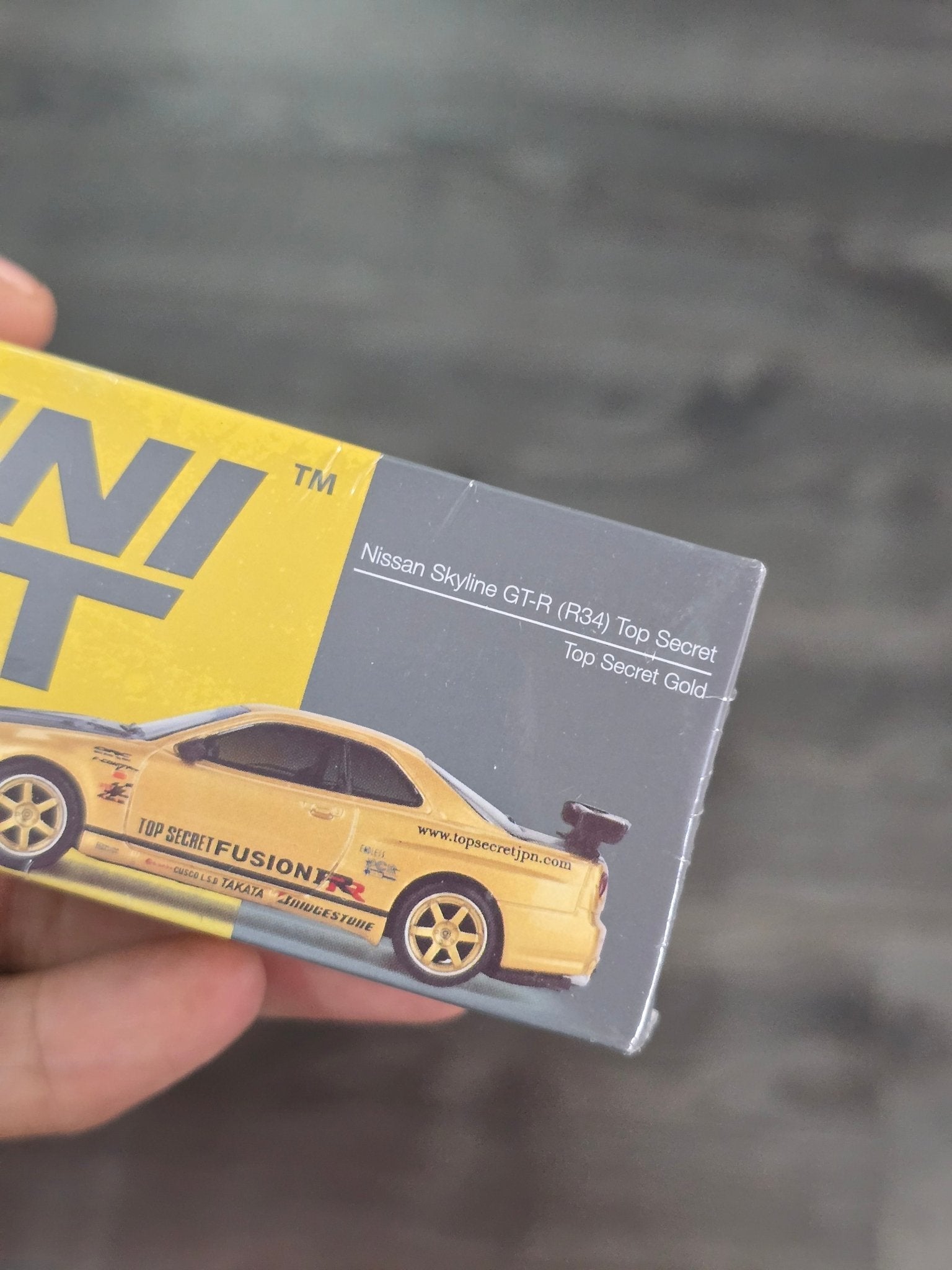 Mini GT Nissan Skyline GT - R (R34) Top Secret (Gold) - Sealed Box - Kinder Logs